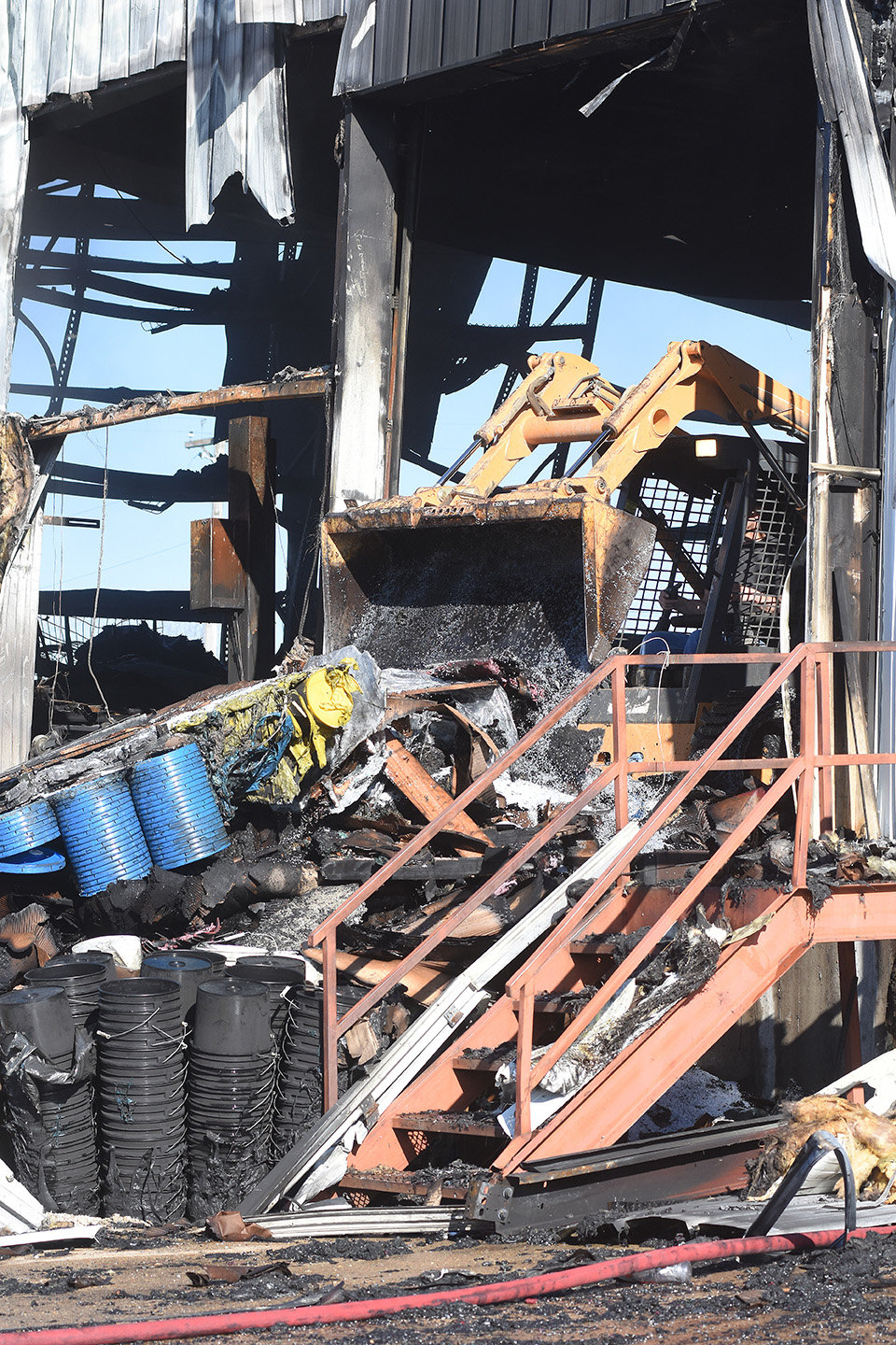 Plastic buckets and lids were among items manufactured at the plant which were being removed from the still smoldering fire late Tuesday morning.